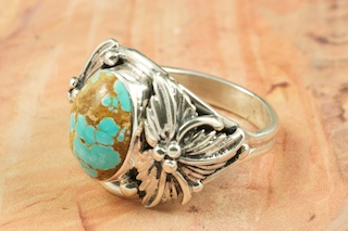 Genuine Number 8 Turquoise set in Sterling Silver Ring. The Number 8 mine is located in Eureka County Nevada. Since 1976 there has been no Number 8 Turquoise mined. There is however, an existing stock pile that Mr. Dowell Ward, the last owner of the Number 8 mine, had stocked away for later sorting. The Turquoise is a collector's item--because once the reserve is gone there will be no more material released onto the market. The Gold Mining Company owns the claim to the Number 8 mine and it has been swallowed up by the gold mining operations. This is some of the last Number 8 Turquoise to be had and will be a great addition to your collection. Created by Navajo Artist Bobby Piaso. Signed by the artist.